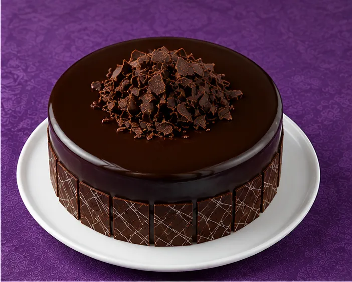 Chocolate cake with glossy ganache and chocolate flakes