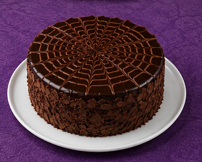 Chocolate cake with spiderweb glaze and chocolate flakes